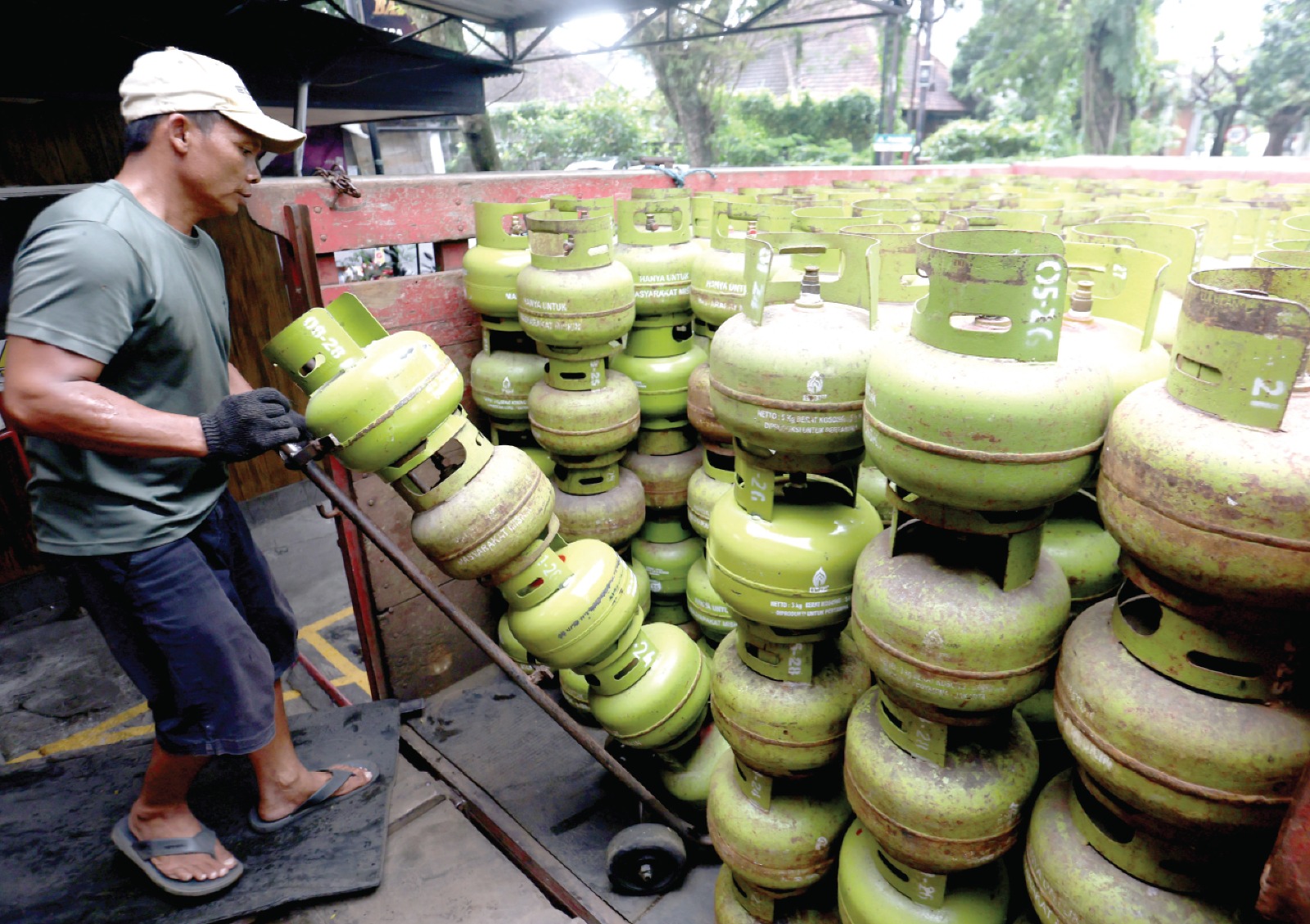STOK AMAN: Seorang pegawai menata Elpiji 3 kilogram ke bak truk untuk segera dikirim ke pelanggan kemarin. DARMONO/RADAR MALANG