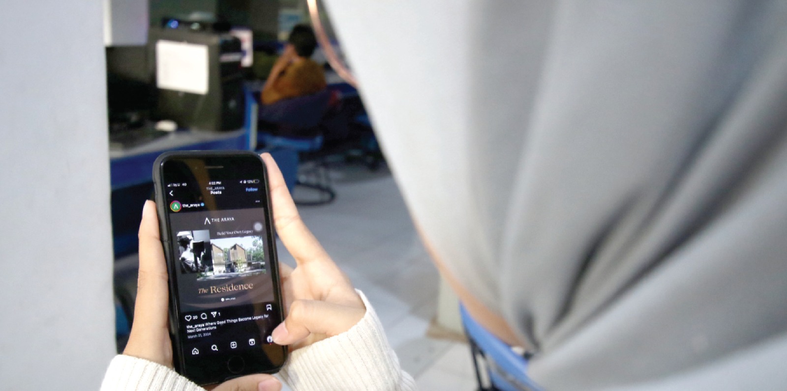 CARI HUNIAN: Seorang pekerja melihat iklan salah satu rumah subsidi di media sosial. SATRIA CAYHONO/RADAR MALANG