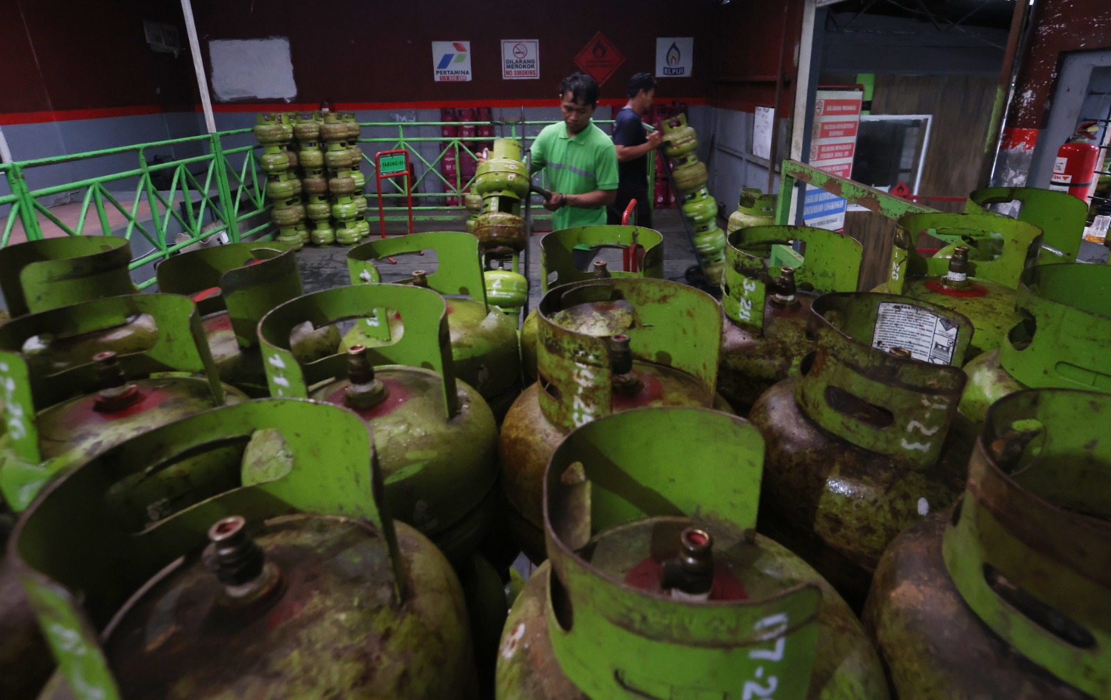 STOK MELIMPAH: Pekerja menata tabung LPG 3 kilogram di Agen LPG Pulosari kemarin (13/1). Harga LPG bersubsidi itu naik mulai besok (15/1). DARMONO/ RADAR MALANG