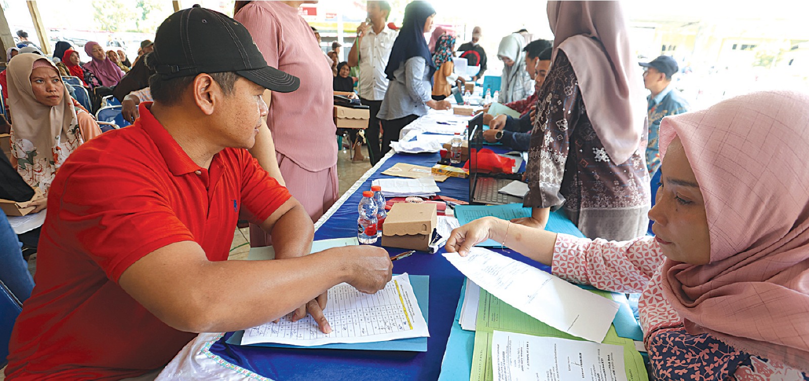 AGRARIA: Ratusan warga antre mengambil sertifikat di kantor Desa Jenggolo, Kecamatan Kepanjen, kemarin (15/1). Mereka mendapatkan sertifikat tanah melalui program PTSL. DARMONO/RADAR MALANG