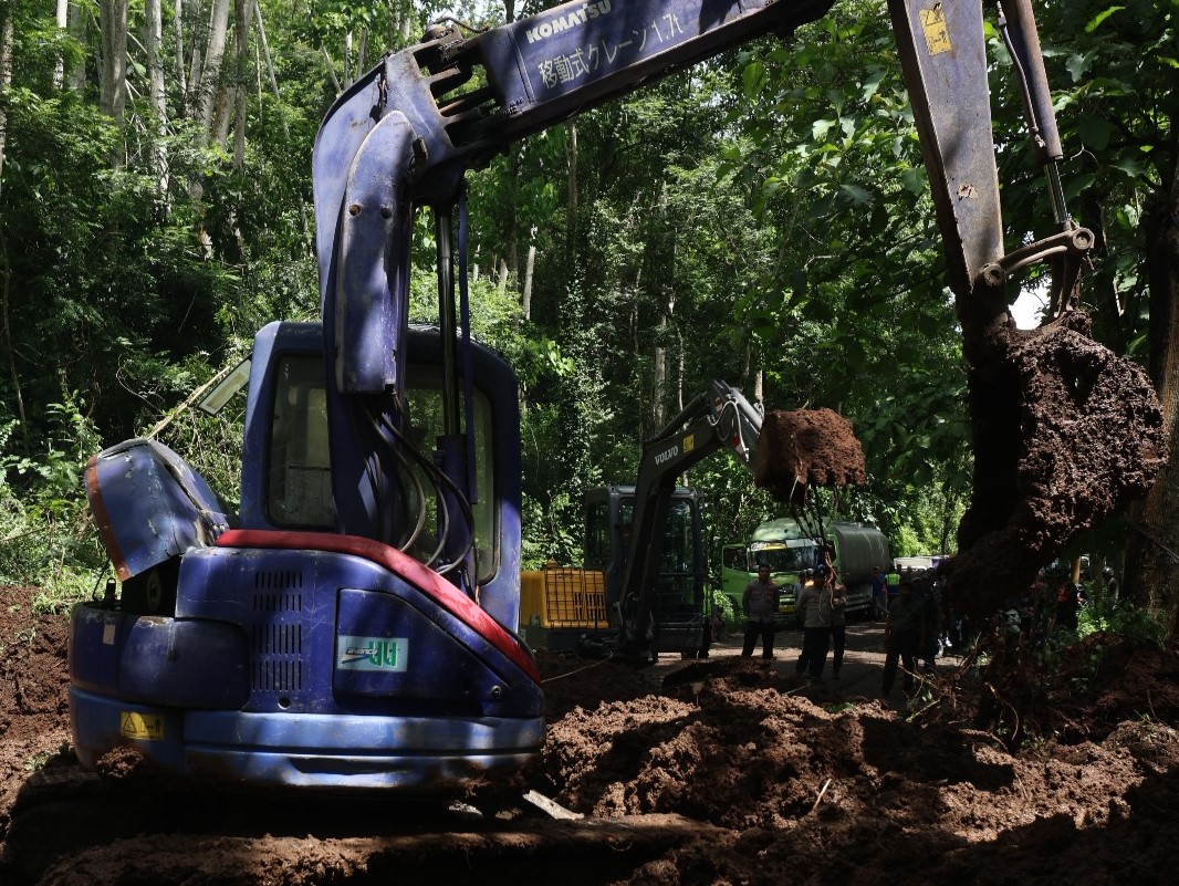MEMAKAN WAKTU TIGA JAM: Ekskavator diterjunkan untuk evakuasi material longsoran di Raya Gunung Geger, Desa Sumberejo, Kecamatan Pagak. Foto bawah, kemacetan panjang terjadi selama proses evakuasi.