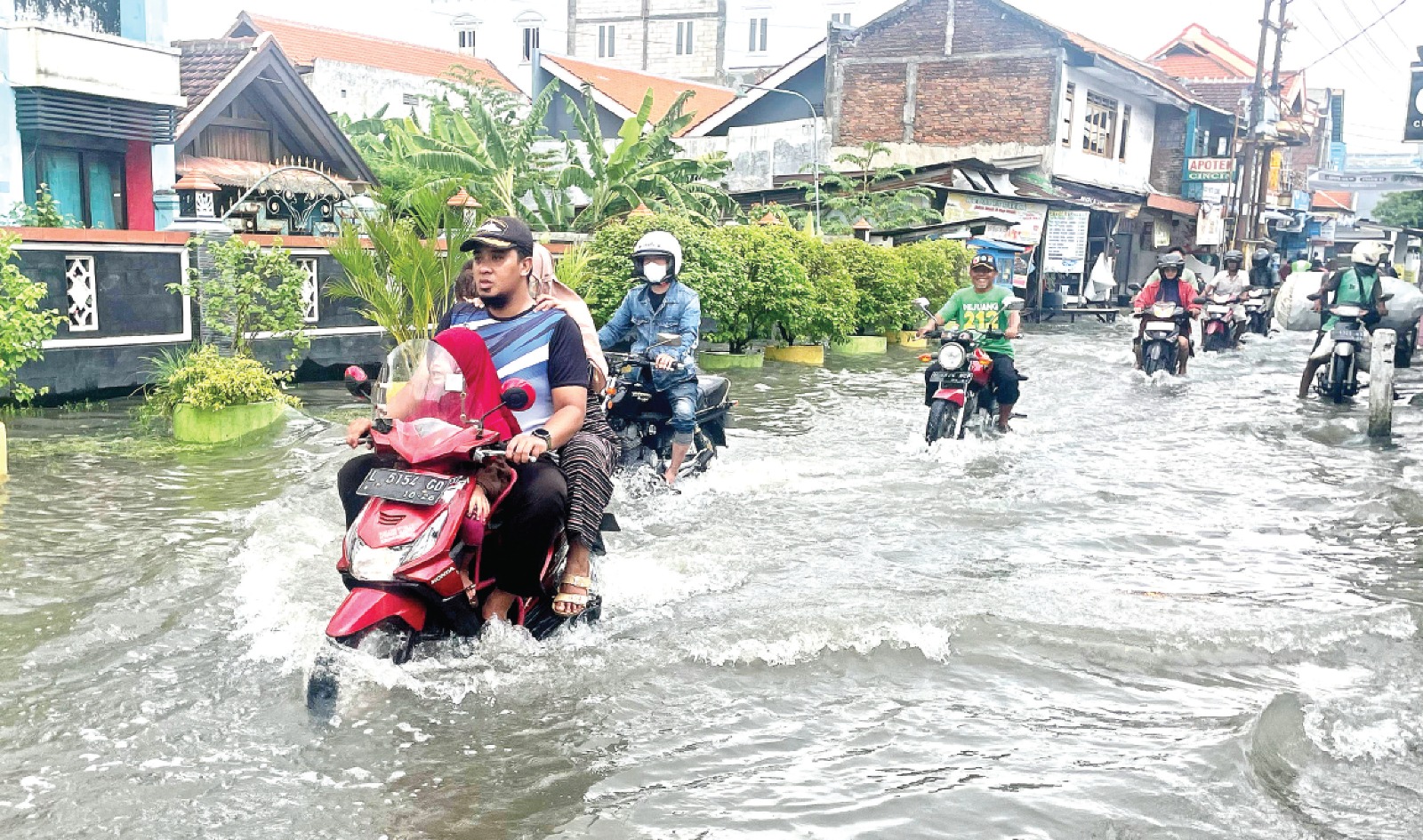 CUKUP PARAH: Warga Perumahan Taman Waru Permai menerjang banjir yang sudah menggenang sejak Selasa (14/1) petang. DOKUMEN JAWA POS