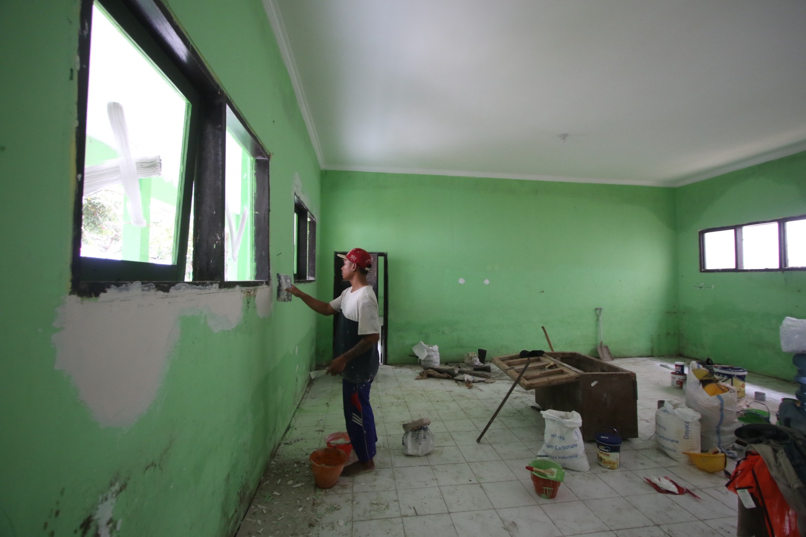 PARTISIPASI SWASTA: Para pekerja melakukan perbaikan gedung SDN Ketawanggede, Kecamatan Lowokwaru, menggunakan dana CSR yang sudah dimulai sejak November 2024. SATRIA CAHYONO/RADAR MALANG