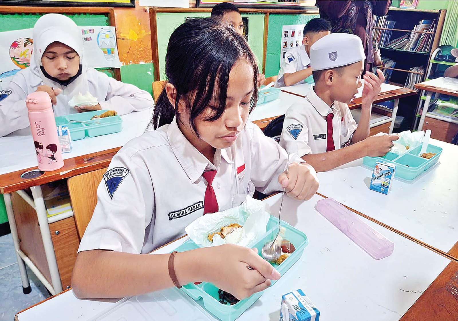 BERGIZI: Siswa SDN Lowokwaru 3 menyantap menu makan bergizi gratis (MBG) pada Senin (13/1) lalu. NABILA AMELIA/RADAR MALANG
