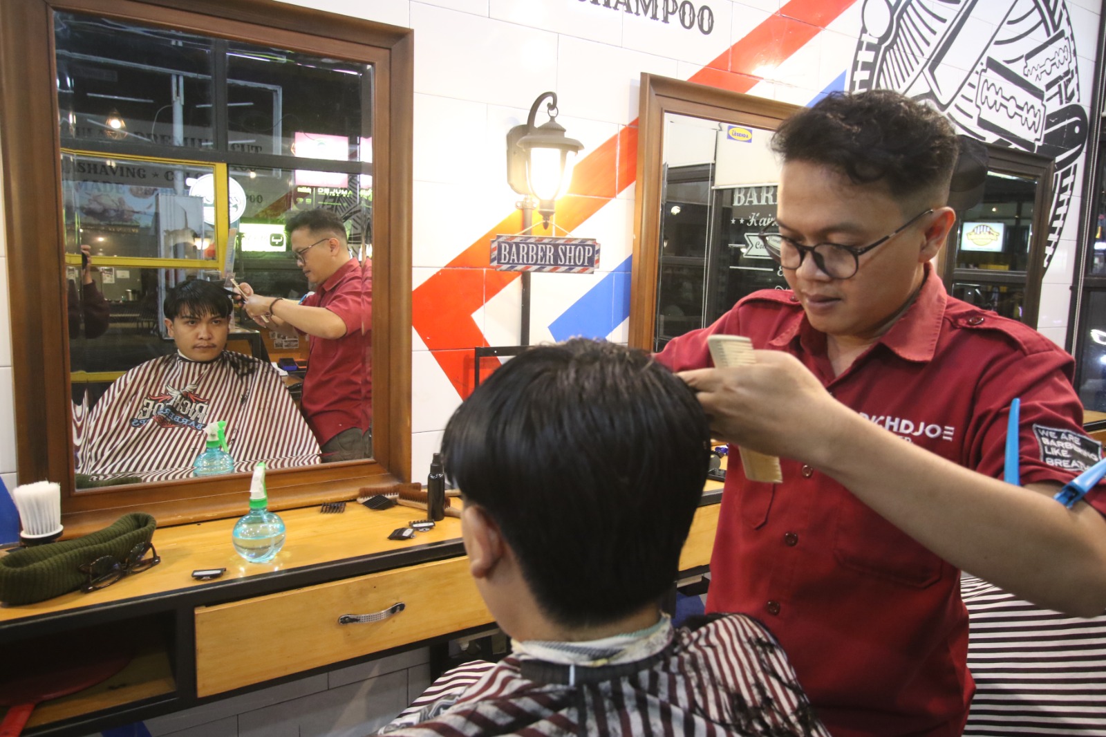 PELOPOR: Salah satu barberman di Richdjoe Barbershop melayani pelanggan, Kamis lalu (16/1). SATRIA CAHYONO / RADAR MALANG