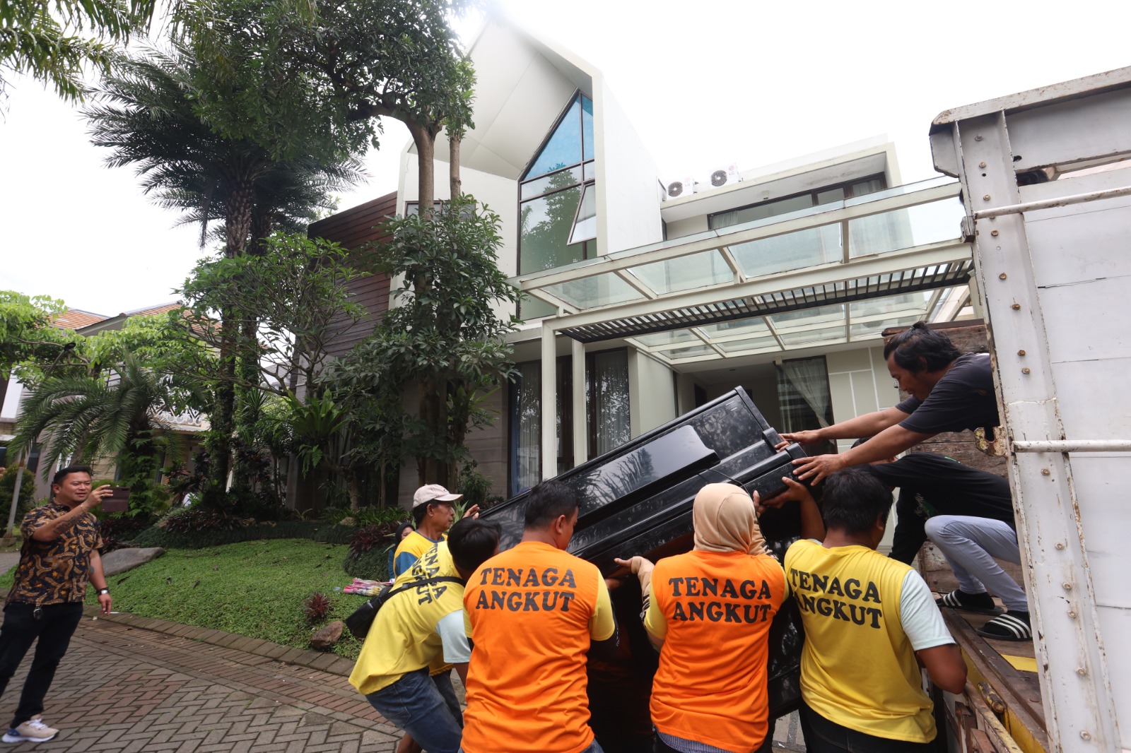 SETELAH LELANG: Petugas Pengadilan Negeri Malang mengangkut barang-barang dari dalam rumah yang disita di Perumahan Permata Jingga Blok West Area, Kelurahan Tunggulwulung, Kecamatan Lowokwaru, kemarin