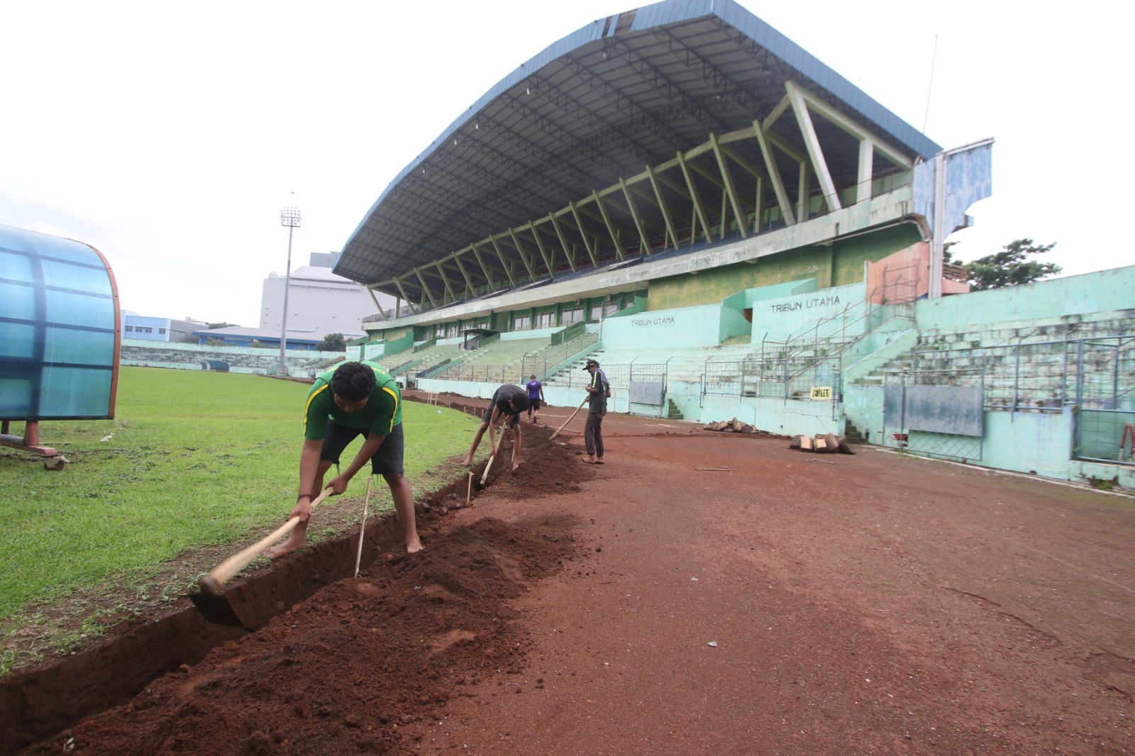 TAHAP AWAL: Sejumlah pekerja menggali tanah di sekitar lapangan rumput Stadion Gajayana untuk pembuatan drainase kemarin (22/1). SATRIA CAHYONO/RADAR MALANG