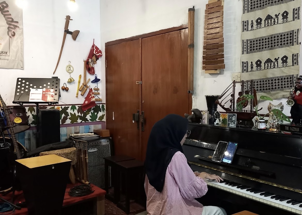 Pengunjung kafe Wedangan Budhe dapat memainkan alat musik yang tersedia (anisaazizu).
