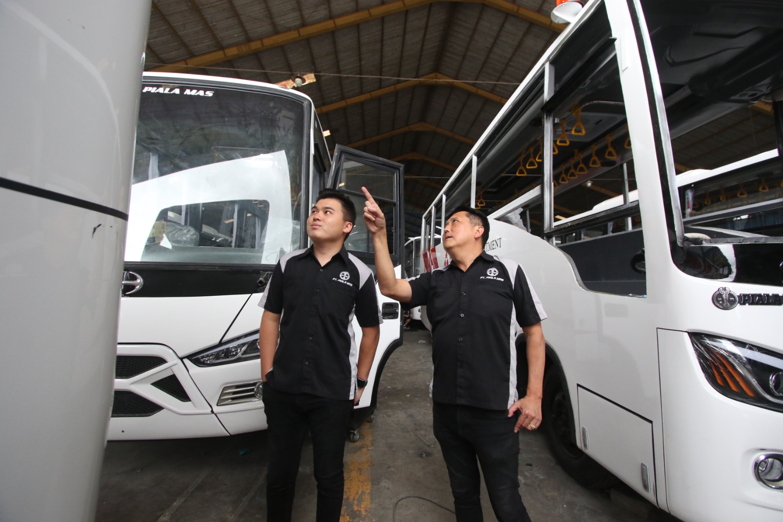 TERUS BERKEMBANG: Direktur PT Piala Mas Industri Indra Soedjoko (kanan) dan putranya, Bryan Soedjoko menunjukkan beberapa unit bus yang sedang dalam proses finishing di karoseri Piala Mas.