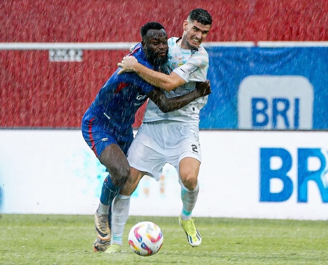 MANAJEMEN LANGSUNG RAPAT: Charles Lokolingoy (kiri) ditempel ketat center back Persib Bandung Nick Kuipers di laga kemarin sore (24/1). Singo Edan kembali gagal mendulang poin. MEDIA OFFICER AREMA FC
