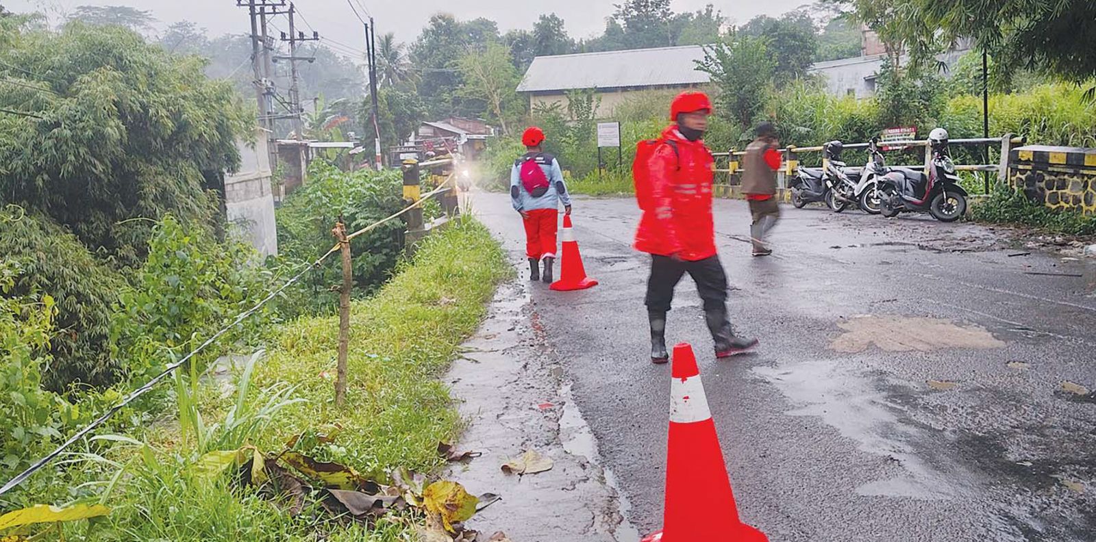 DIDOMINASI LONGSOR: Personel dari BPBD Kabupaten Malang meninjau dan menangani longsor di jembatan Dusun Ngrambon, Kecamatan Karangploso kemarin. (BPBD KABUPATEN MALANG FOR RADAR KANJURUHAN)