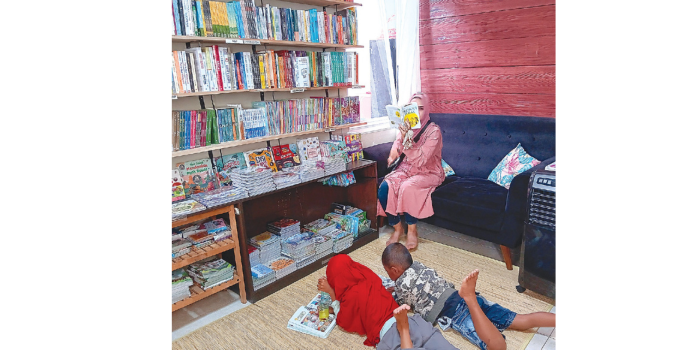 LITERASI: Pengunjung bersantai sambil membaca buku di Book by Ibuk, desa Sekarpuro, kecamatan Pakis kemarin (26/1). di rumah baca ini terdapat lebih dari 500 buku. (INDAH MEI YUNITA/RADAR KANJURUHAN)