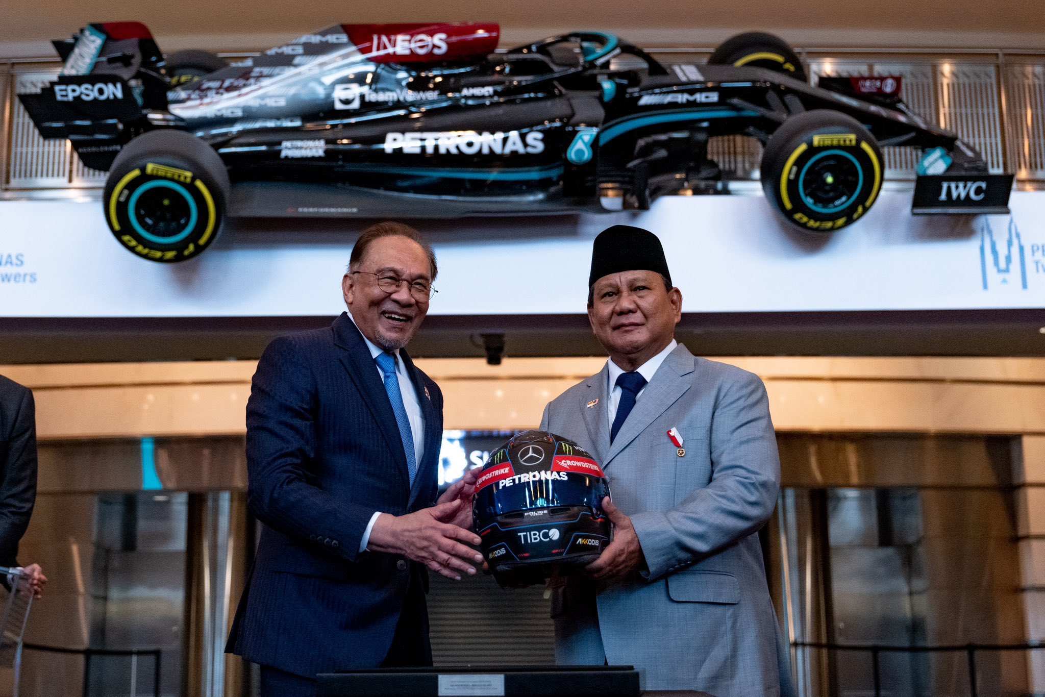 Presiden RI Prabowo Subianto (kanan) foto bersama PM Malaysia Anwar Ibrahim sambil memegang helm F1 milik George Russell. (Instagram pribadi Anwar Ibrahim)