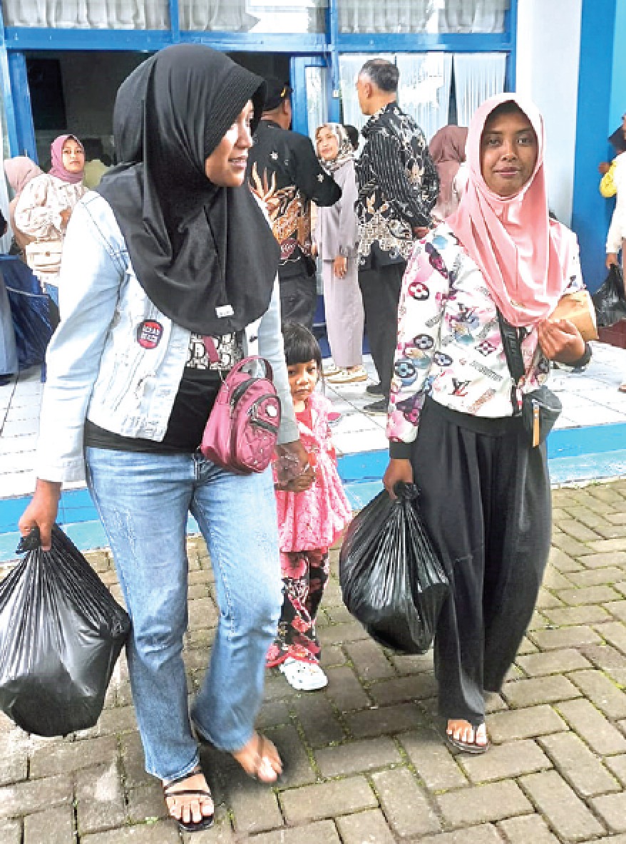 BERGEMBIRA: Para anggota Koperasi  Susu SAE Pujon menerima sembako usai rapat pra-RAT. KHOLID AMRULLAH/RADAR MALANG