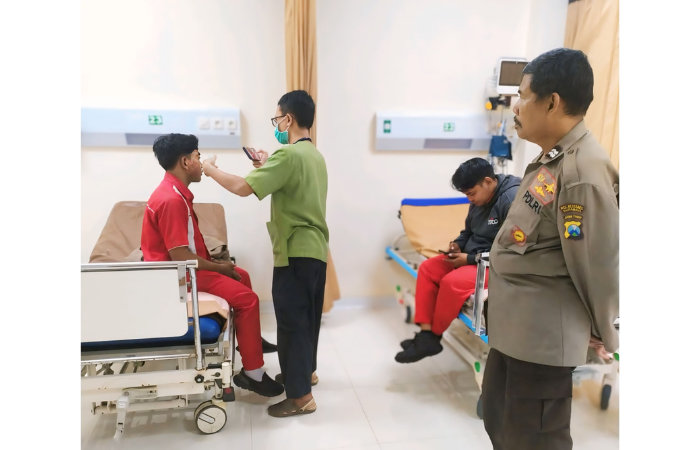 VISUM: Personel Polsek Tegal sari mendam pingi Aziz (kiri) dan Reza saat menjalani pemeriksaan di RSPAL dr Ramelan Surabaya. (POLSEK TEGALSARI)