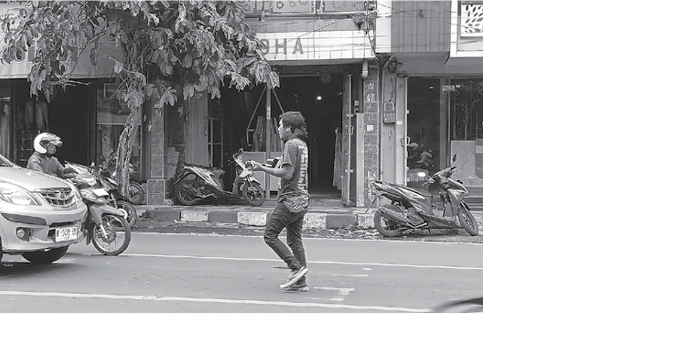 MERESAHKAN: Seorang pengamen beraksi di simpang empat Jalan A. Yani, Kepanjen. Mereka menyatroni mobil pribadi, angkutan umum, hingga kendaraan roda dua yang melintas INDAH MEI YUNITA/RADAR KANJURUHAN