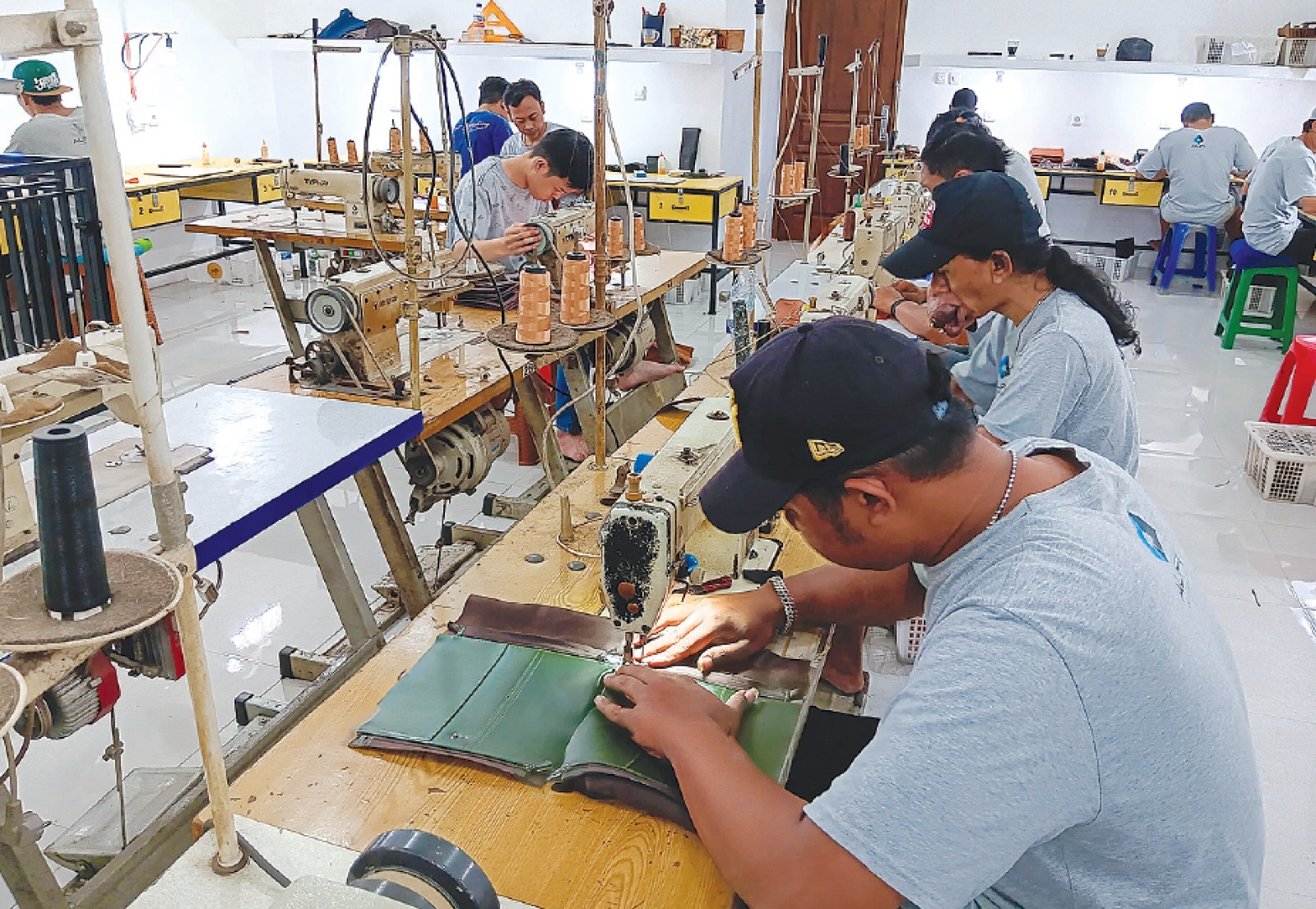 HARUS TELITI: Beberapa pekerja di Alfi Leather di Desa Ngadilangkung, Kecamatan Kepanjen membuat dompet kulit. Dua pekerja di antaranya penyandang disabilitas. INDAH MEI YUNITA/RADAR KANJURUHAN