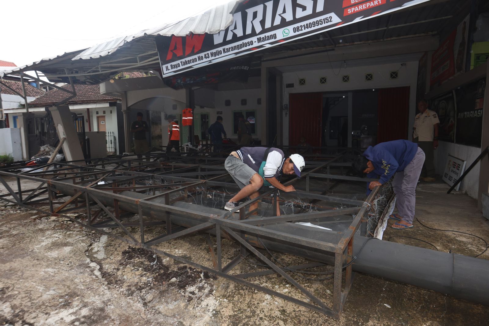 SAMBUNGAN RAPUH: Papan reklame berukuran panjang 6 enam meter dan lebar 4 meter di Jalan Raya Kepuharjo, Desa Ngijo, Kecamatan Karangploso roboh dan menimpa kanopi bengkel mobil kemarin pagi (30/1).