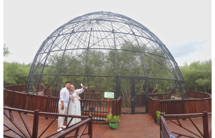 JADI PILIHAN: Dua wisatawan melakukan selfie di salah satu wahana Kebun Raya Mangrove. (AKHMAD KHUSAINI/ JAWA POS)