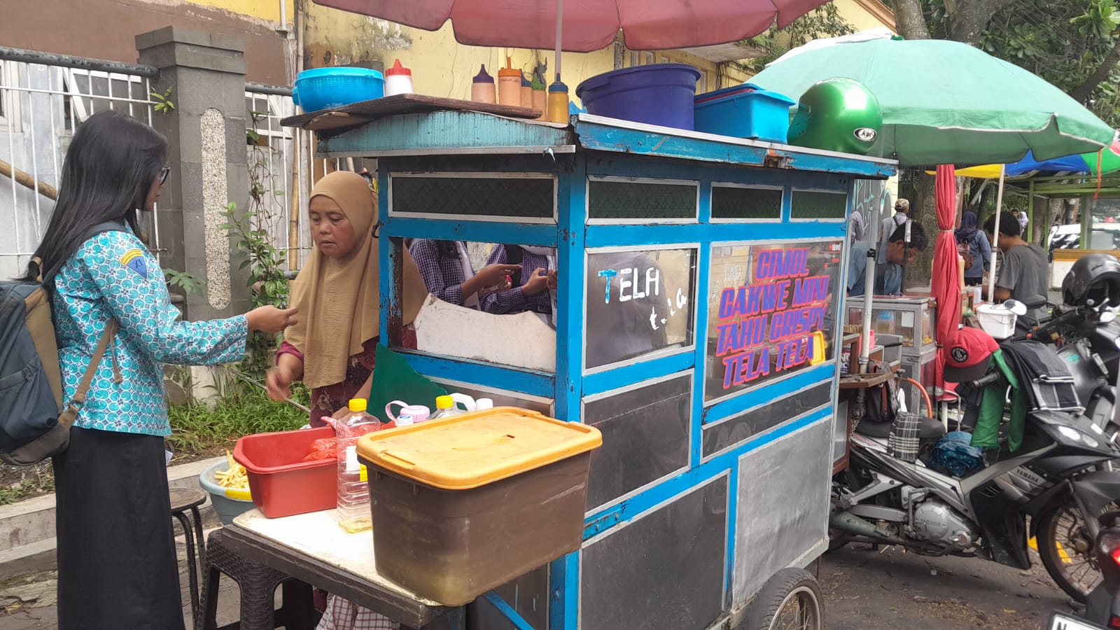 Gerobak biru penjual tela tela depan MTs Khadijah Malang. (RAISYA SEKAR FOR&nbsp;RADAR&nbsp;MALANG)
