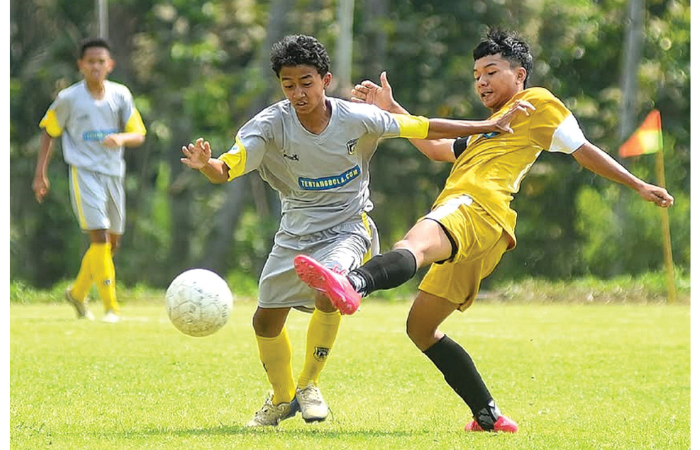 KAWAH CANDRADIMUKA: Pemain Malang United U-17 (kiri) berebut bola dengan penggawa SSB Lawang dalam laga MJL U-17, beberapa waktu lalu. (MO MALANG UNITED FOR RADAR MALANG)