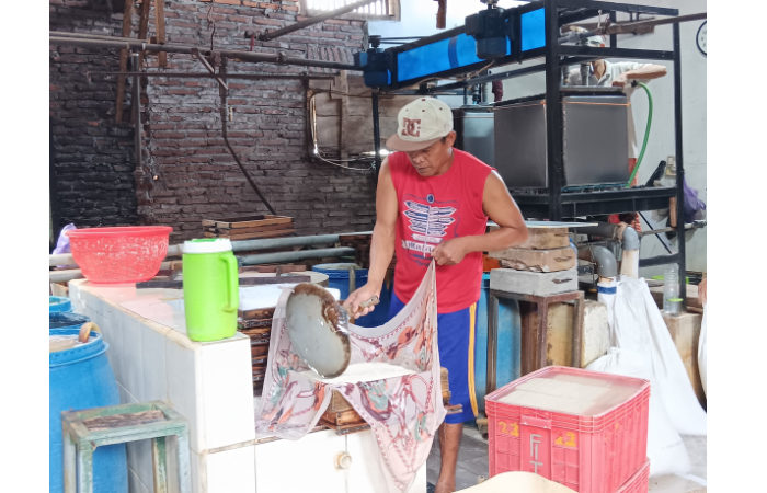 INDUSTRI RUMAHAN: Seorang pegawai di rumah produksi desa Bocek, Kecamatan Karangploso memproses kedelai menjadi tahu kemarin (6/2). (INDAH MEI YUNITA/RADAR KANJURUHAN)