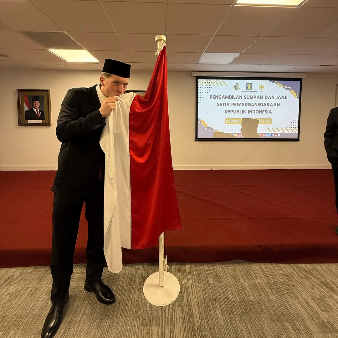 Ole Romeny mencium bendera merah putih setelah melakukan pengambilan sumpah WNI. (Instagram @erickthohir)