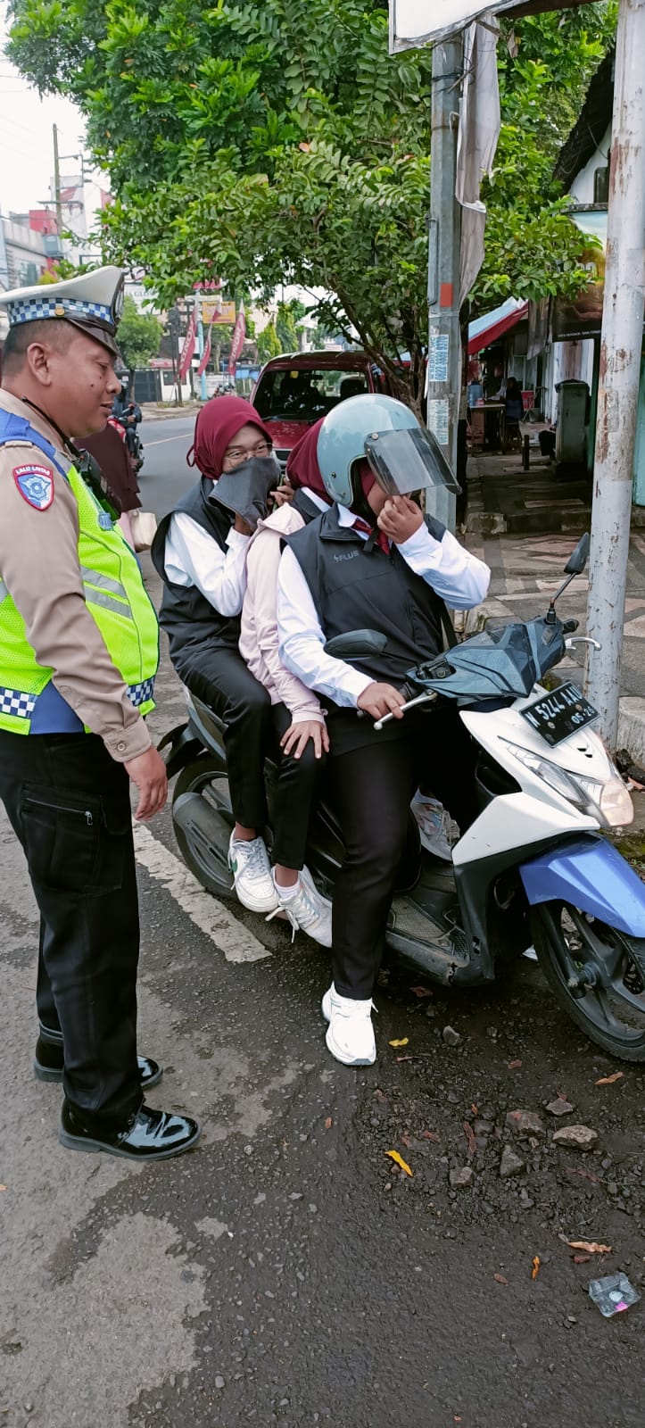 Polisi memberhentikan pengendara yang tidak memakai helm sekaligus berboncengan tiga di Jalan Mondoroko, Kecamatan Singosari kemarin (11/2)