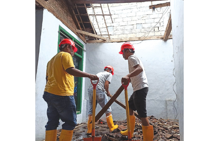 BENCANA: Tim dari BPBD Kabupaten Malang menurunkan genting di rumah Supardi, warga RT 06 RW 12 Dusun Pijiombo, Desa Wonosari, kemarin (10/2). (BPBD KABUPATEN MALANG FOR RADAR KANJURUHAN)
