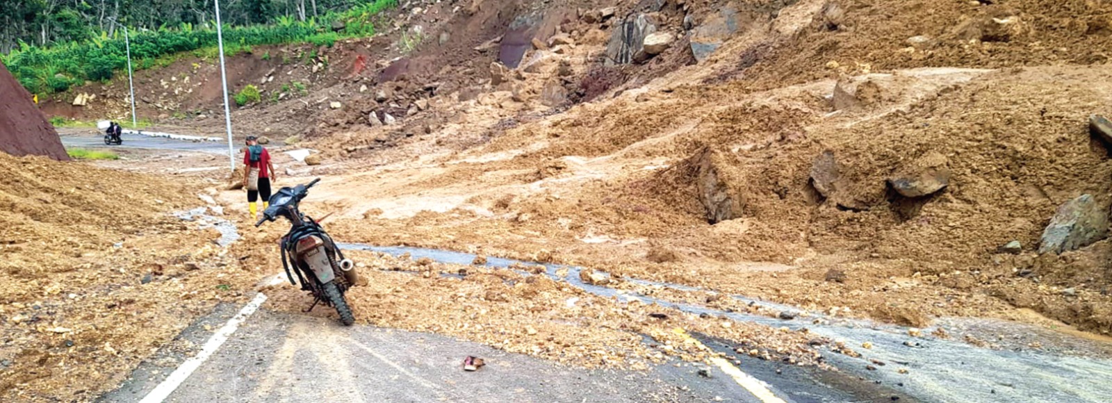 TANAH TIDAK STABIL: Material longsoran berupa tanah dan batu masih menutup sebagian aspal jalan di sekitar Kelok 9 Jalur Lingkar Selatan hingga kemarin (12/2). (CAMAT DONOMULYO FOR RADAR MALANG)