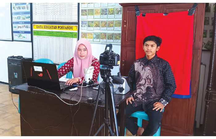 ADMINDUK: Staf Dispendukcapil Kabupaten Malang yang bertugas di kantor Desa Ardimulyo, Kecamatan Singosari membantu warga melakukan perekaman IKD. (INDAH MEI YUNITA/RADAR KANJURUHAN)