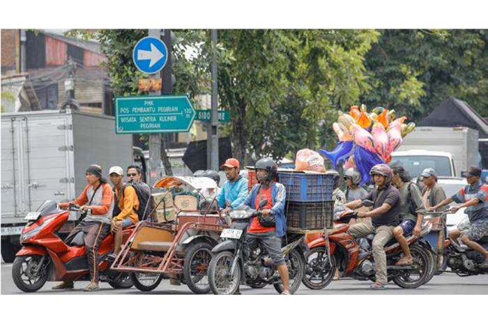 TIDAK TERATUR: Sejumlah kendaraan roda dua di simpang empat Pegirian yang terlihat tidak mematuhi aturan dari tidak memakai helm sampai berhenti di batas lampu perlintasan. (DIPTA WAHYU/JAWA POS)