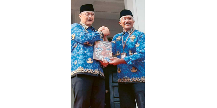 KENANG-KENANGAN: Penjabat Wali Kota Malang Iwan Kurniawan (kiri) menerima buku rangkuman 11 program prioritas yang sudah dijalankan sejak Agustus 2024 dari Sekda Erik Setyo Santoso kemarin (17/2).