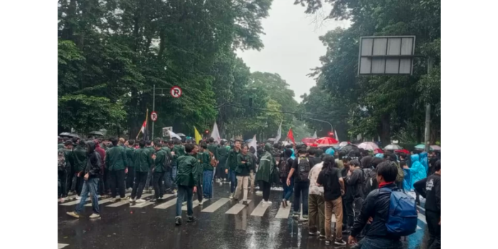 Mahasiswa tetap melakukan demo di depan Gedung DPRD Kota Bandung walaupun di bawah guyuran hujan (Magang Ayobandung/Fawwaz Rafif)