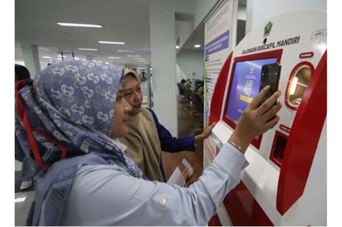 BERMANFAAT: Dua warga memanfaatkan layanan Anjungan Dukcapil Mandiri (ADM) di Mal Pelayanan Publik (MPP), Kamis lalu (20/2). (SATRIA CAHYONO / RADAR MALANG)