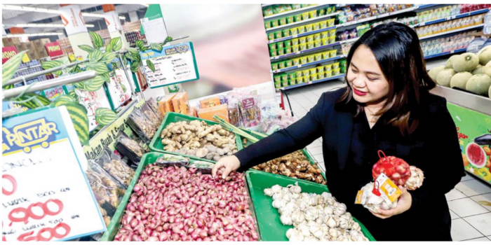 HARGA MULAI NAIK: Seorang ibu rumah tangga memilih bawang merah dan bawang putih di supermarket kemarin. (RIANA SETIAWAN/JAWA POS)