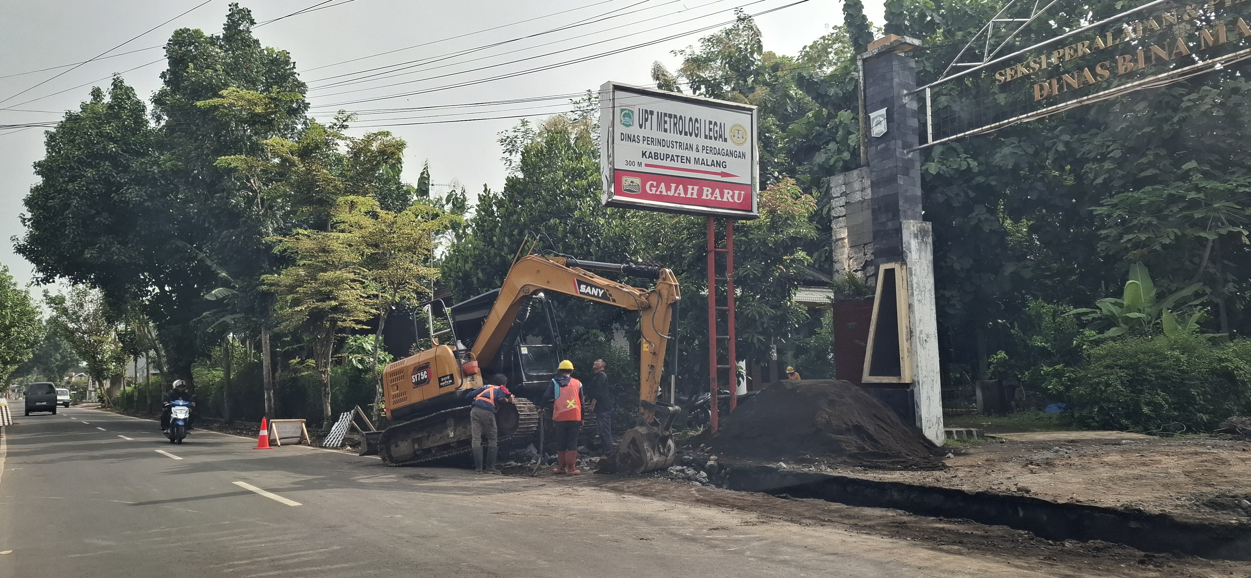 CEGAH BANJIR: Alat berat diterjunkan untuk mengeruk drainase di jalur Kendalpayak-Kepanjen kemarin (26/2)