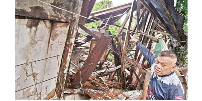 BIASA DIGUNAKAN WARGA: Salah satu warga menunjukkan bagian atap rumah di Jalan Bareng Kartini, yang ambruk mulai Selasa sore (25/2). Rumah itu ditinggalkan sejak 2019. (NABILA AMELIA/RADAR MALANG)