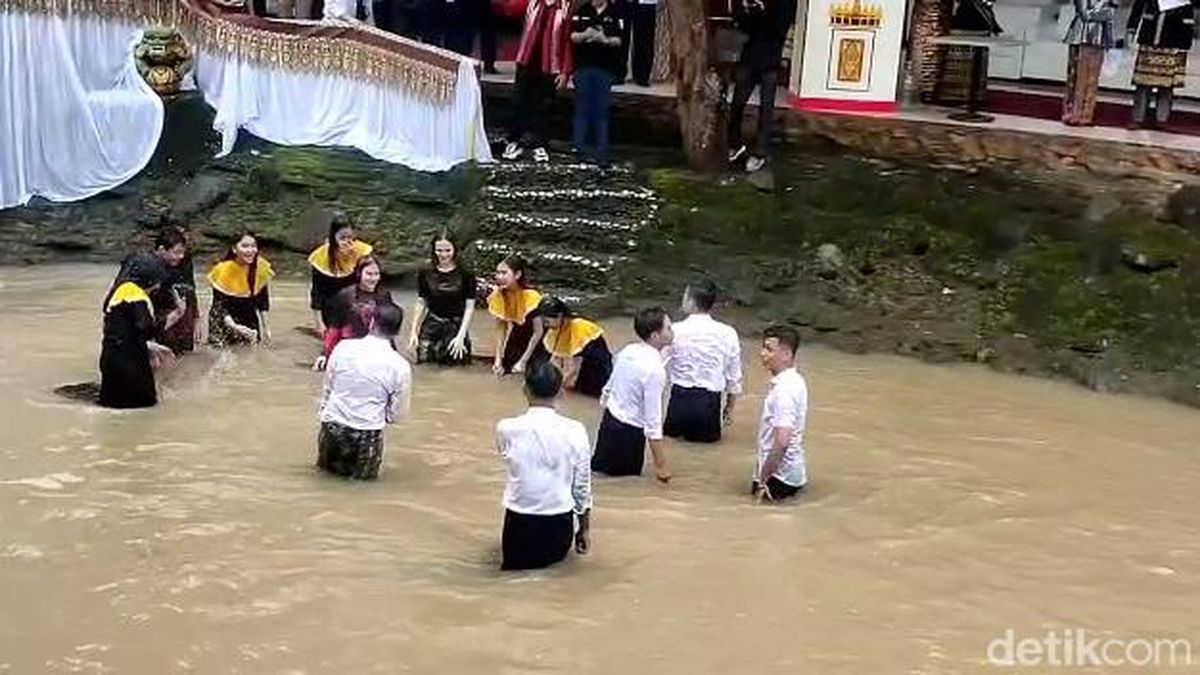 Muda-mudi sedang melakukan tradisi "Belangiran" di sungai. (detik.com)