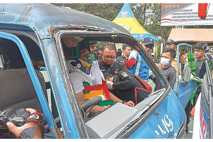 PERTOLONGAN: Personel satlantas dan relawan mempraktikkan cara menolong korban laka yang terjepit mikrolet di halaman Mapolres Malang kemarin. (NAHDIATUL AFFANDIAH/RADAR KANJURUHAN)