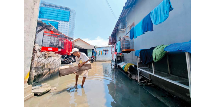 PERLAHAN SURUT: Warga Kedung Baruk menge ringkan barangba rang yang terendam banjir kemarin siang.