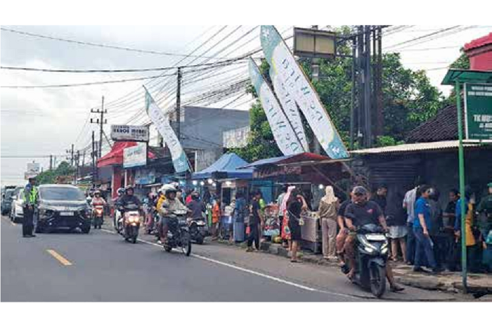 Petugas dari aparat kepolisian mengatur arus lalu lintas di depan pasar takjil Pakisaji kemarin (2/3). Polisi gencar melakukan patroli untuk mengurai kemacetan. (BIYAN MUDZAKY/RADAR KABUPATEN MALANG)