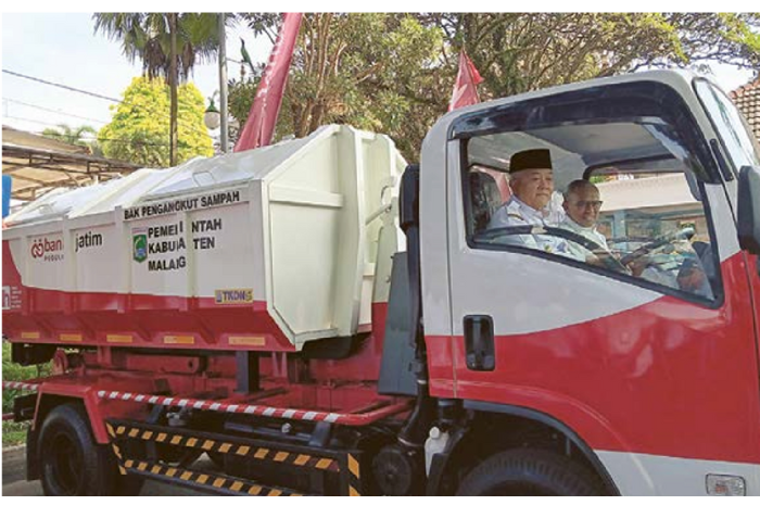 ARMADA BARU: Bupati Malang H M. Sanusi didampingi Direktur Manajemen Risiko Bank Jatim Eko Susetyono menjajal arm roll truck. (Prokopim Kabupaten Malang/Indah Mei Yunita)