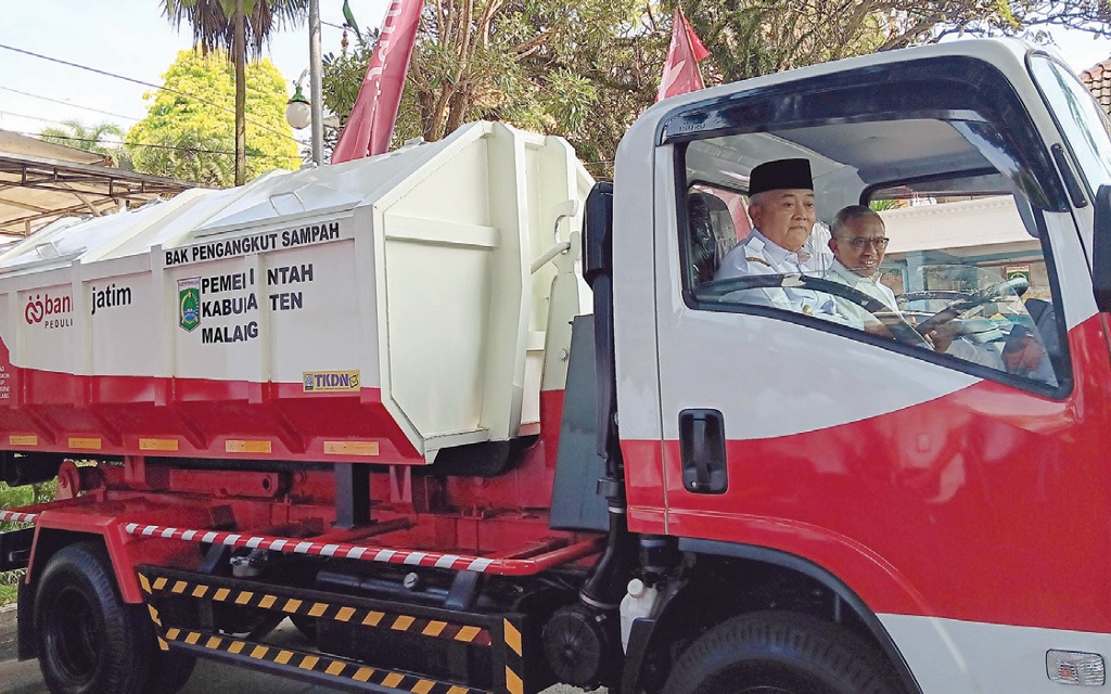 ARMADA BARU: Bupati Malang H M. Sanusi didampingi Direktur Manajemen Risiko Bank Jatim Eko Susetyono menjajal arm roll truck.