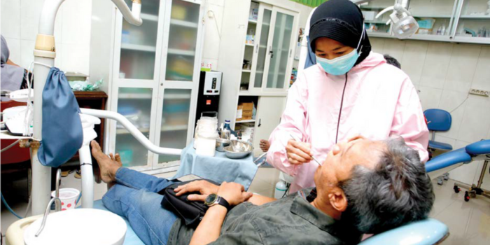 DIFASILITASI PEMERINTAH: Seorang dokter gigi di Puskesmas Sidoarjo memeriksa mulut pasien kemarin siang.