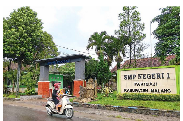 TINGKATKAN KUALITAS: Pengendara melintas di depan SMPN 1 Pakisaji kemarin (6/3). (INDAH MEI YUNITA/RADAR KANJURUHAN)