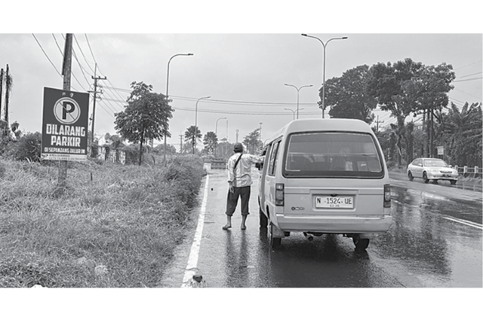 HAMBAT LALIN: Mikrolet berhenti di jalur pintu masuk tol Lawang untuk menunggu penumpang kemarin (6/3). (NAHDIATUL AFFANDIAH/RADAR KANJURUHAN)
