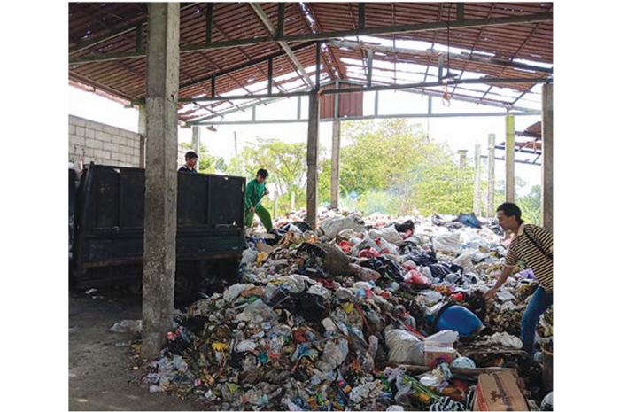 BUTUH ARMADA: Seorang pekerja memilah sampah di TPS 3R Annadhofah, Desa Ngijo, Kecamatan Karangploso kemarin (6/3). (INDAH MEI YUNITA/RADAR KANJURUHAN)