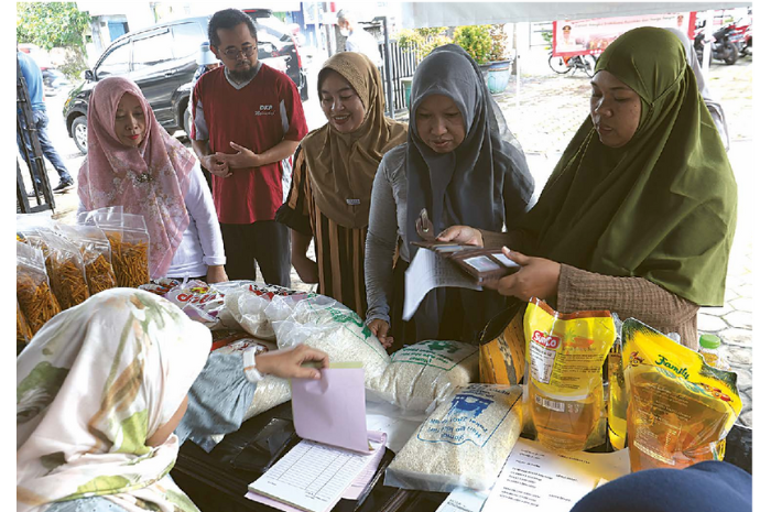 ANTUSIASME: Warga antre membeli sembako murah di halaman kantor Dinas Ketahanan Pangan (DKP) Kabupaten Malang kemarin (7/3). (DARMONO/RADAR MALANG)