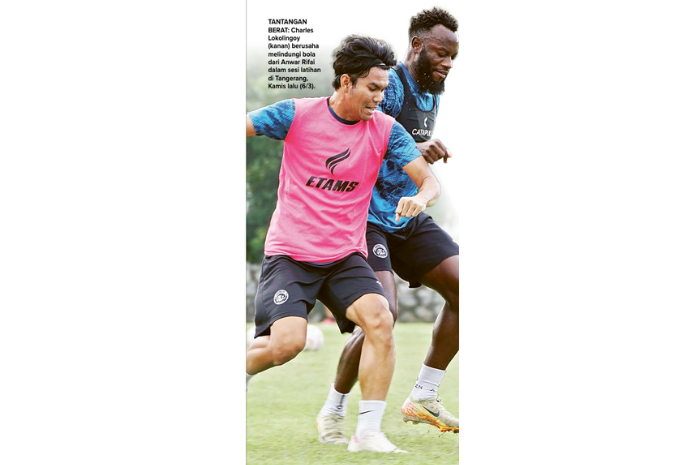 TANTANGAN BERAT: Charles Lokolingoy (kanan) berusaha melindungi bola dari Anwar Rifai dalam sesi latihan di Tangerang, Kamis lalu (6/3). (MO AREMA FC FOR RADAR MALANG)